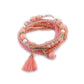 Lovra multi-row beaded bracelet styled with other jewelry on a wooden table