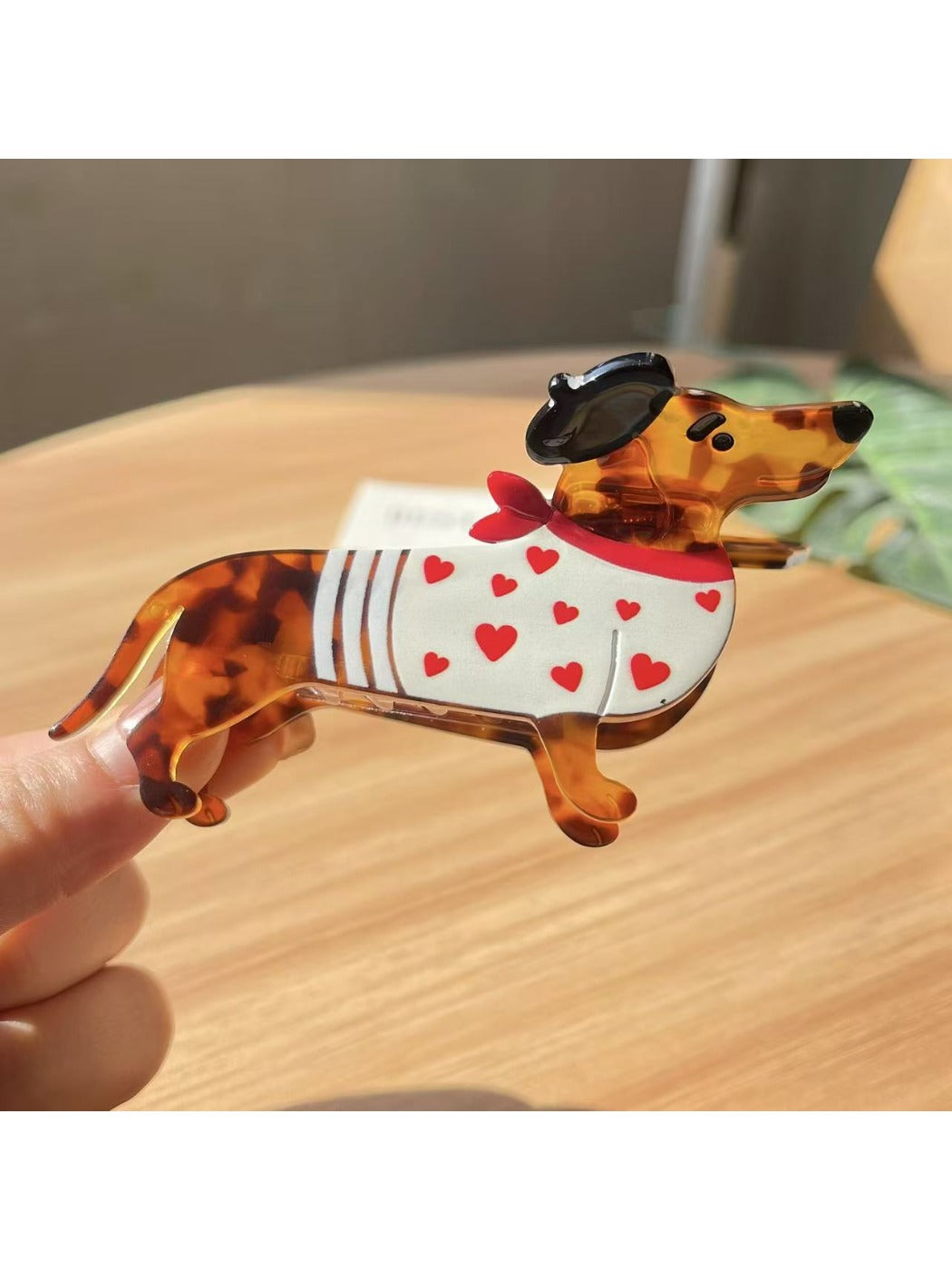 Beau dachshund claw clip placed on wooden surface with natural lighting