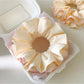 Pink ruffle beige scrunchie styled in a ponytail on a model