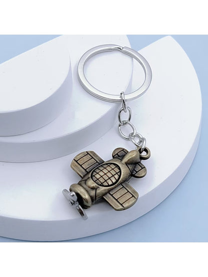 Top view of the airplane keychain highlighting its smooth metallic finish