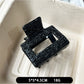 Beau black acetate claw clip partially open to show inner teeth