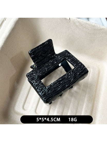 Beau black acetate claw clip partially open to show inner teeth