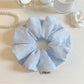 Close-up of Gifty solid color striped scrunchie in pastel tones on white background