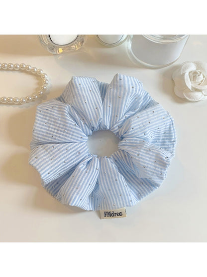 Close-up of Gifty solid color striped scrunchie in pastel tones on white background