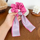 Scrunchie held in hand showing elastic stretch and color pattern