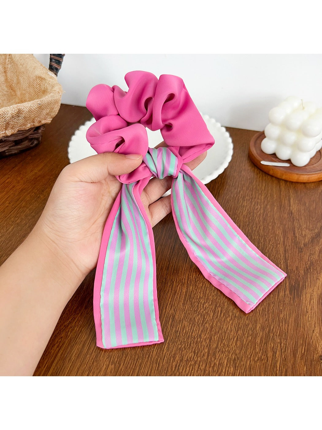 Scrunchie held in hand showing elastic stretch and color pattern