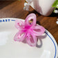 Beau flower hair claw clip displayed on a wooden surface