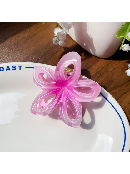 Beau flower hair claw clip displayed on a wooden surface