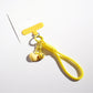 Candy color heart keychain hanging from a bag zipper pull in natural light