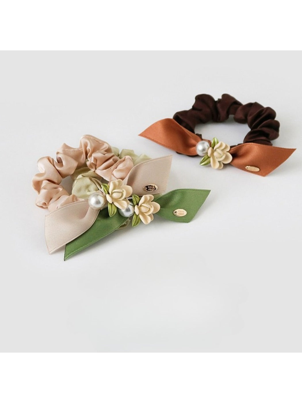 Side view of Gifty hair tie featuring layered fabric flowers in soft pastel colors