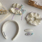 Close-up of Gifty scrunchie headband showing gathered fabric texture in beige