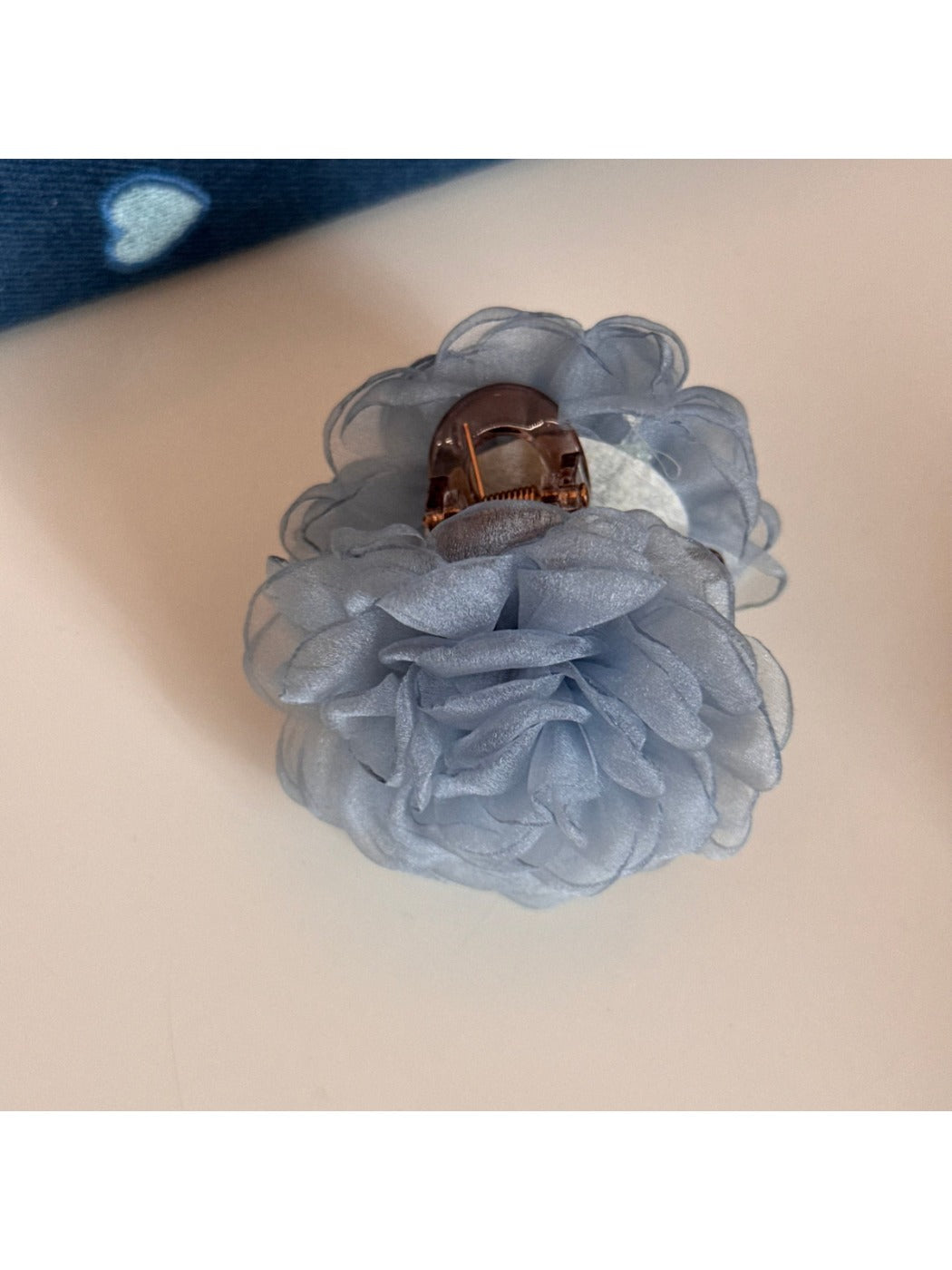 Beau rose hair clip held between fingers showing size