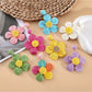 Close-up of Earedge minimalist flower shaped drop earrings on white background