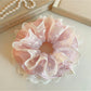 Gifty ruffled scrunchie worn on a wrist showing soft fabric and print details