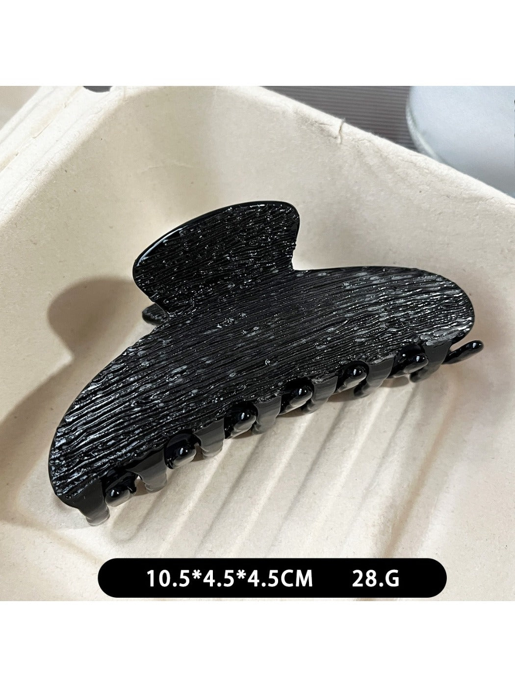 Beau black acetate claw clip displayed on a wooden surface