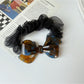 Top view of Gifty mesh bow acetate scrunchie highlighting texture and design