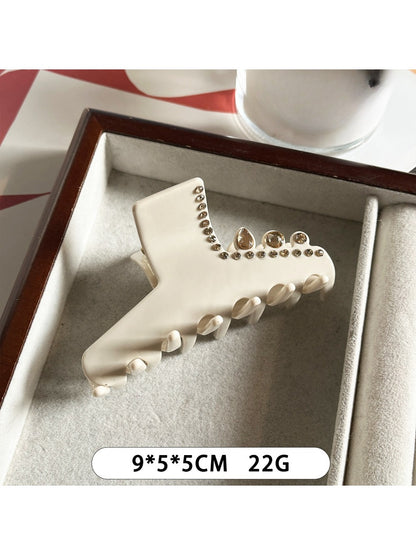 Beau rhinestone embellished claw clip displayed on a textured surface