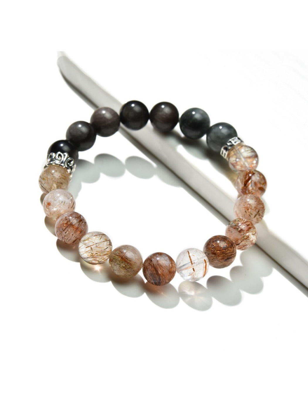 Close-up of Lovra Crystal Obsidian Beaded Bracelet with polished black beads on a white background