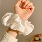 Satin scrunchie styled in a ponytail showcasing the bow pattern