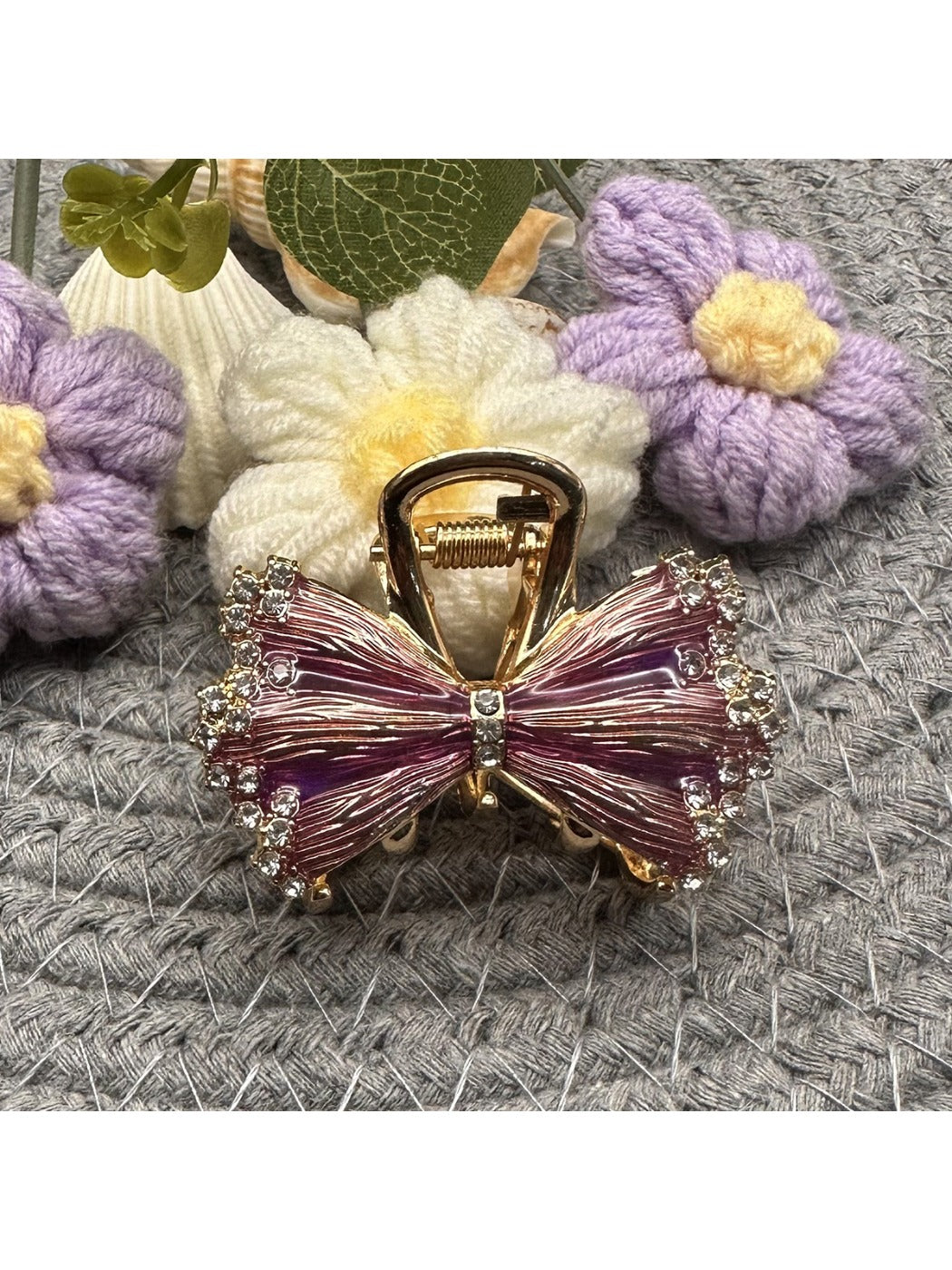 Side view of Beau pleated bow hair clip clipped into dark hair