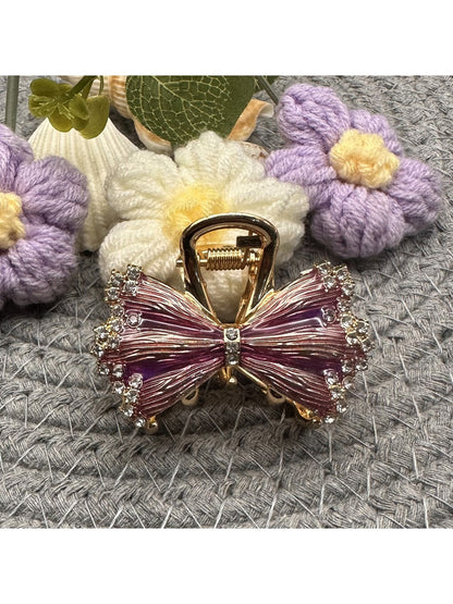 Side view of Beau pleated bow hair clip clipped into dark hair