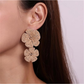 Earedge floral pendant raffia drop earrings hanging on a jewelry stand