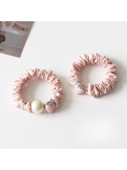 Top view of the strawberry hair tie highlighting the detailed fruit decoration