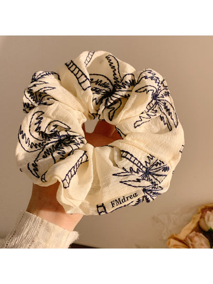 Vintage style scrunchie with coconut tree print on beige fabric
