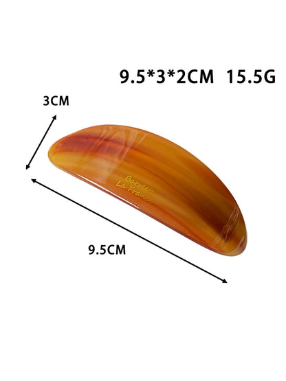 Beau ponytail hair clip holding a section of dark hair in an oval shape