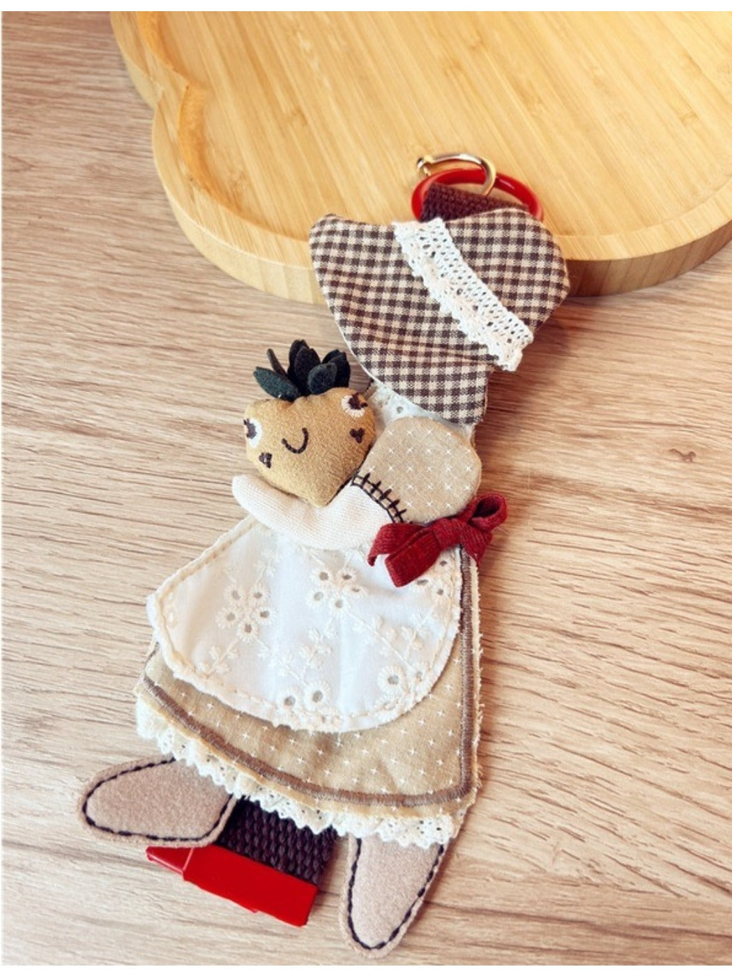 Keypus fabric patchwork keychain hanging from a bag zipper, showing practical use