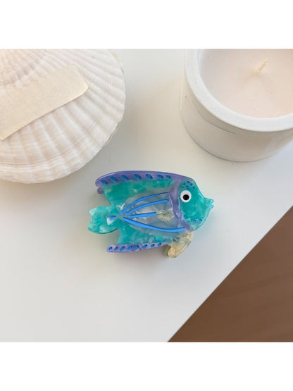 Beau fish claw clip placed on a wooden surface emphasizing vibrant colors