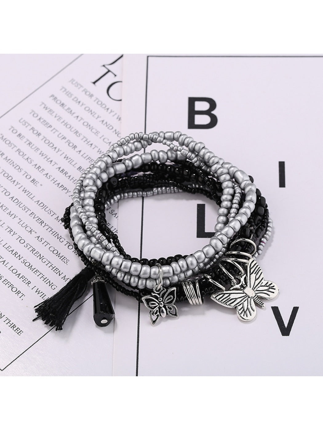 Lovra beaded bracelet with butterfly pendant shown alongside matching jewelry