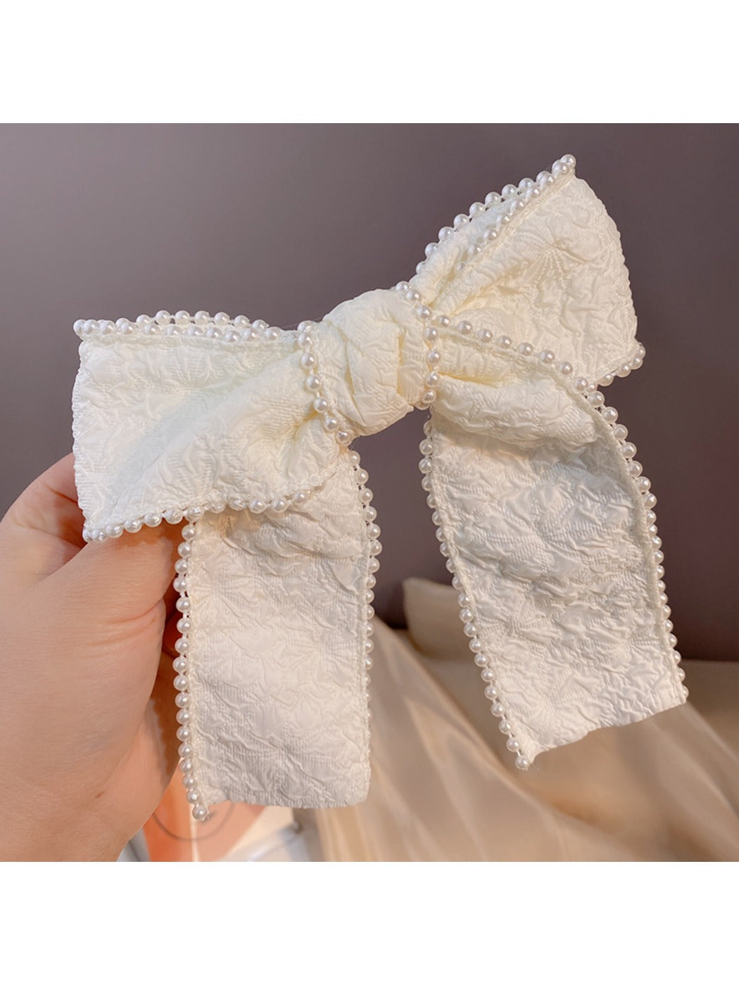 Elegant black headband with a prominent bow embellished with pearls and crystals