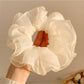 Double layer tulle scrunchie displayed next to matching pastel pink accessories