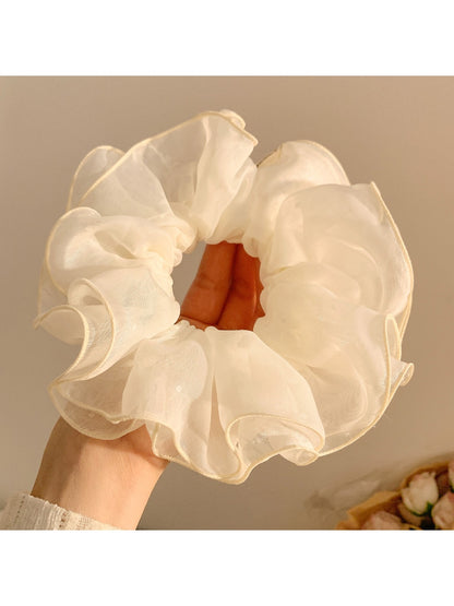 Double layer tulle scrunchie displayed next to matching pastel pink accessories