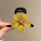 Beau flower-shaped claw clip positioned upright showing full design