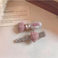 Beau hair clip displayed on a wooden surface highlighting the textured strawberry design