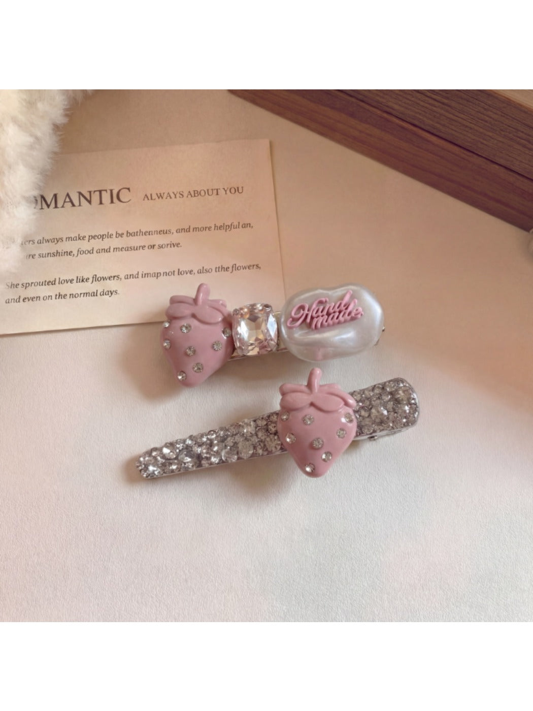 Beau hair clip displayed on a wooden surface highlighting the textured strawberry design