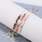 Detailed shot of Lovra bracelet beads with varied colors on woven black cord