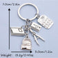 Alloy backpack book keychain attached to a set of keys on a wooden surface