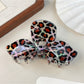 Beau leopard print bow claw clip displayed with matching outfit