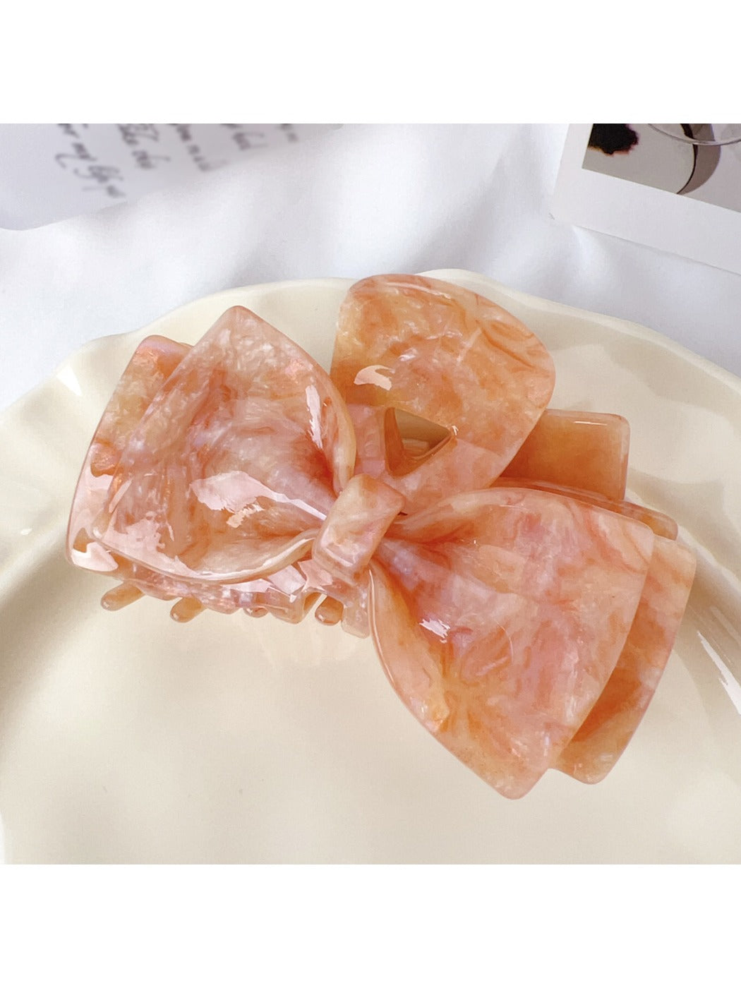 Beau bow shaped claw clip in natural light highlighting color variations