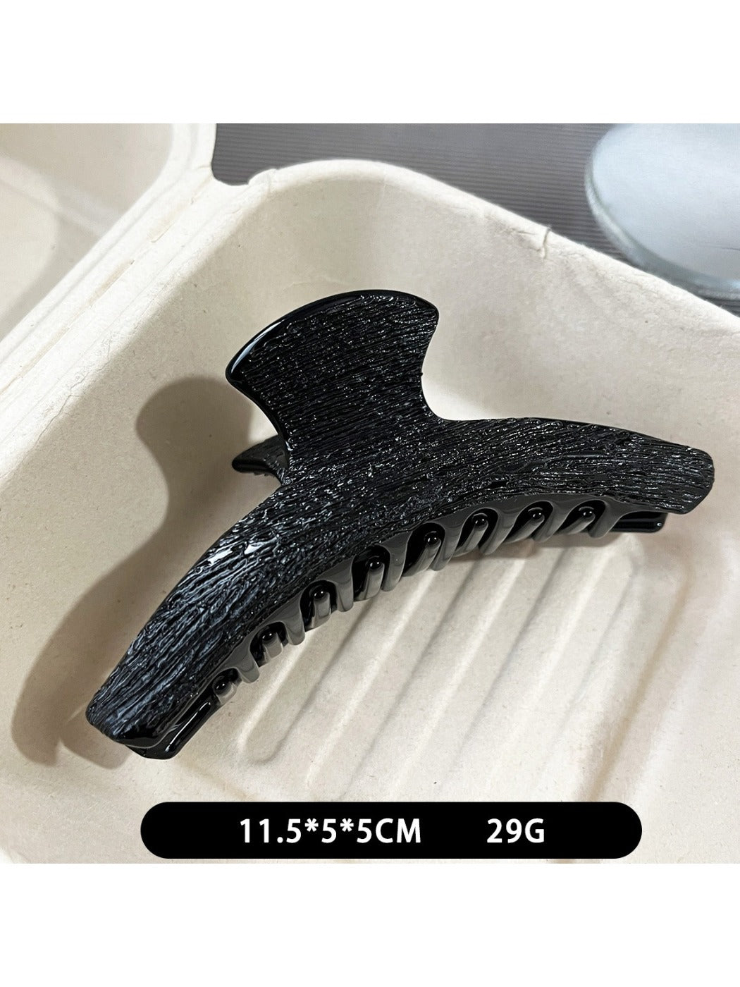 Beau black acetate claw clip holding hair in an updo style