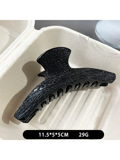 Beau black acetate claw clip holding hair in an updo style