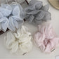 Close-up of Gifty delicate double layer ruffled scrunchie in soft pink fabric