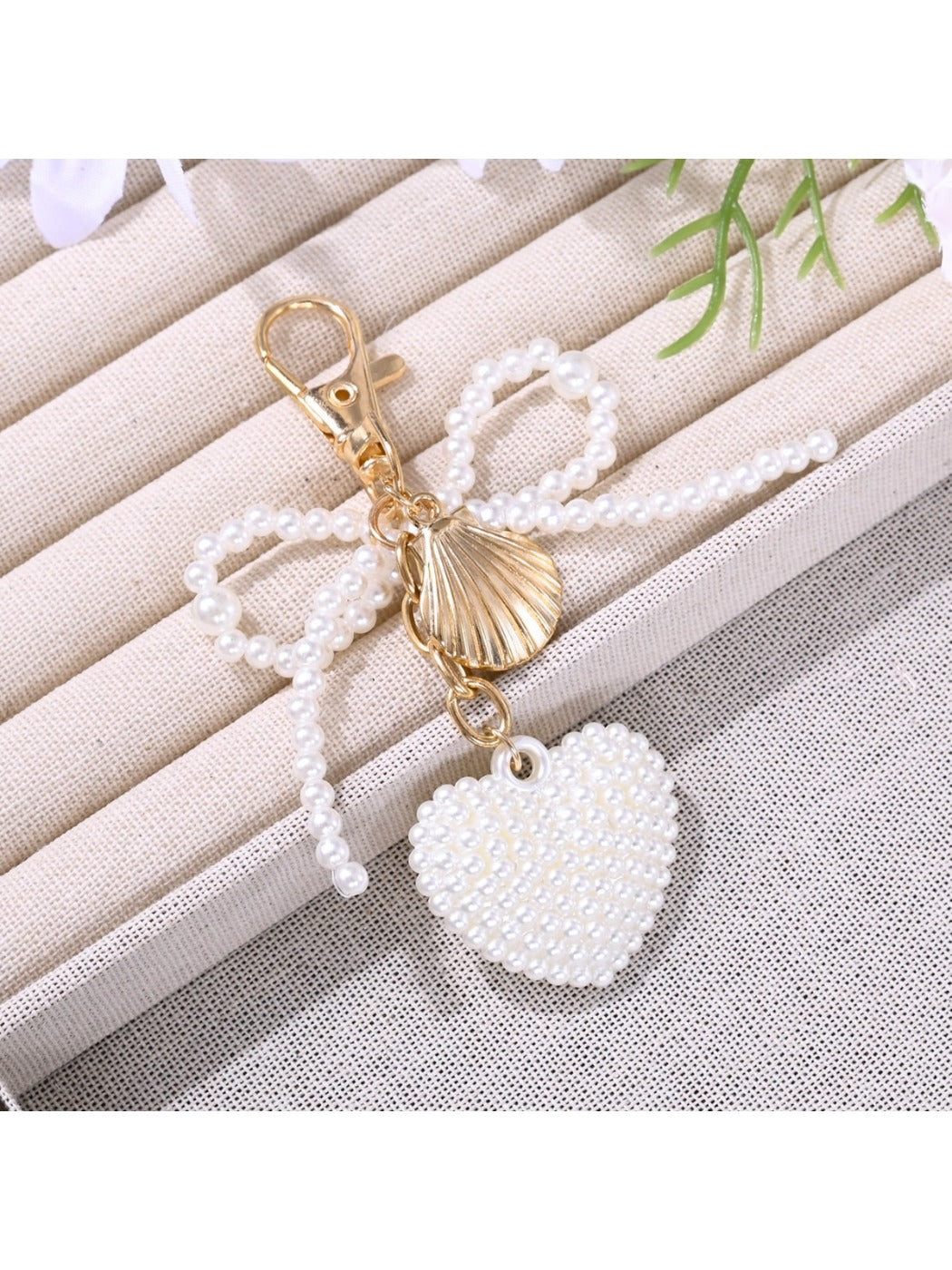 Keypus bow heart shaped keychain shown with other accessories on table