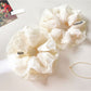 White tulle ruffle scrunchie displayed on a plain white background
