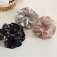 Gifty scrunchie styled on a wrist showing ruffled fabric and floral pattern
