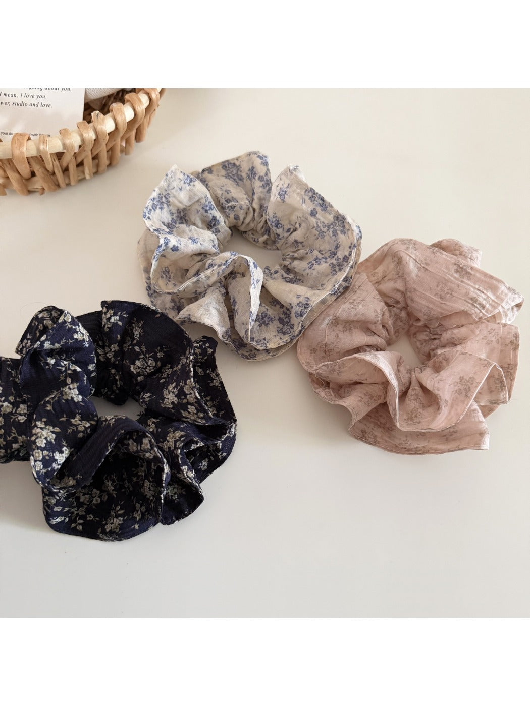 Gifty scrunchie styled on a wrist showing ruffled fabric and floral pattern