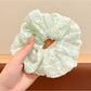 Gifty floral scrunchie next to matching floral accessories